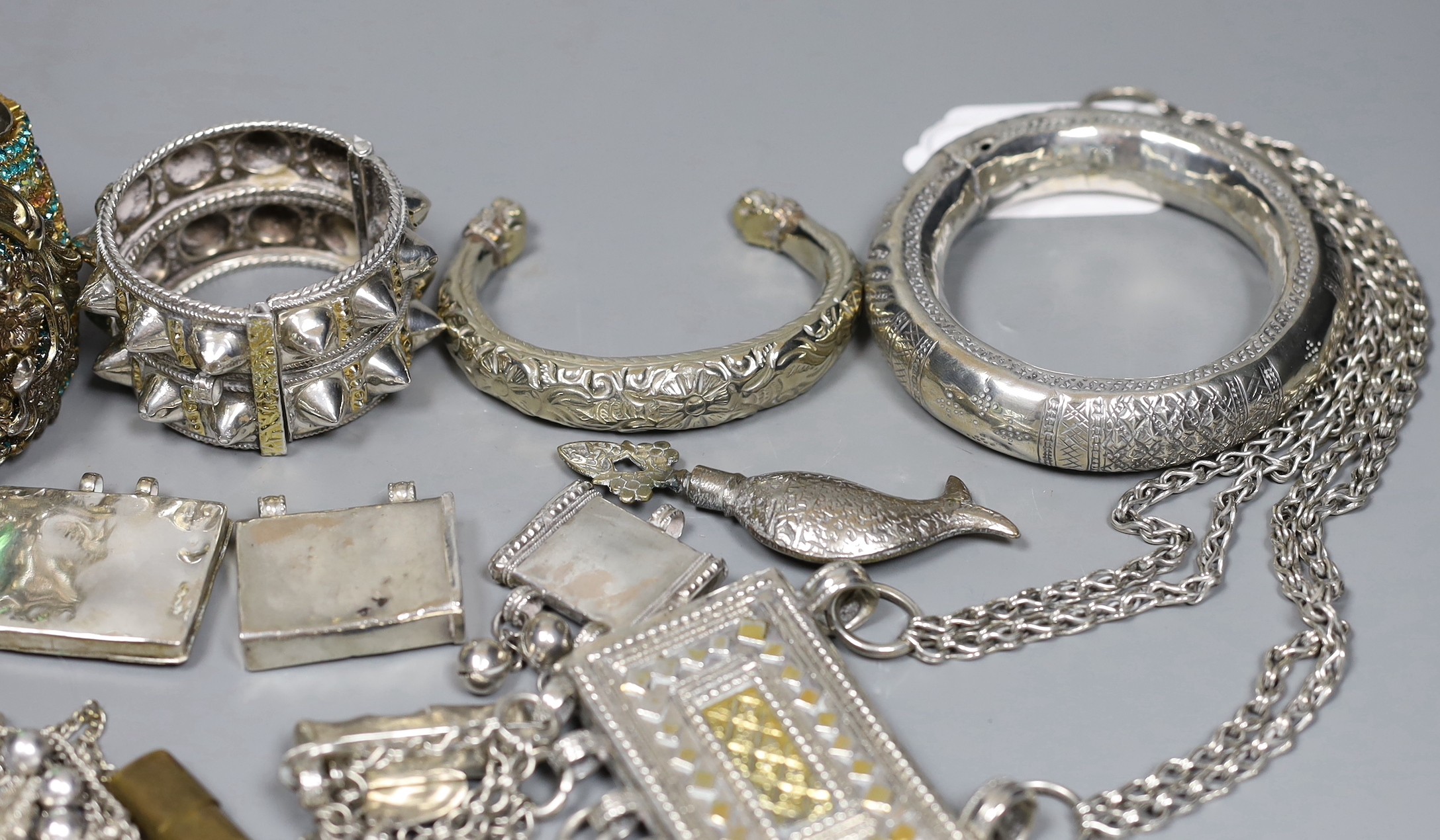 A small group of Middle Eastern mainly white metal jewellery, including bangles, bracelets and an Omani Hirz necklace.